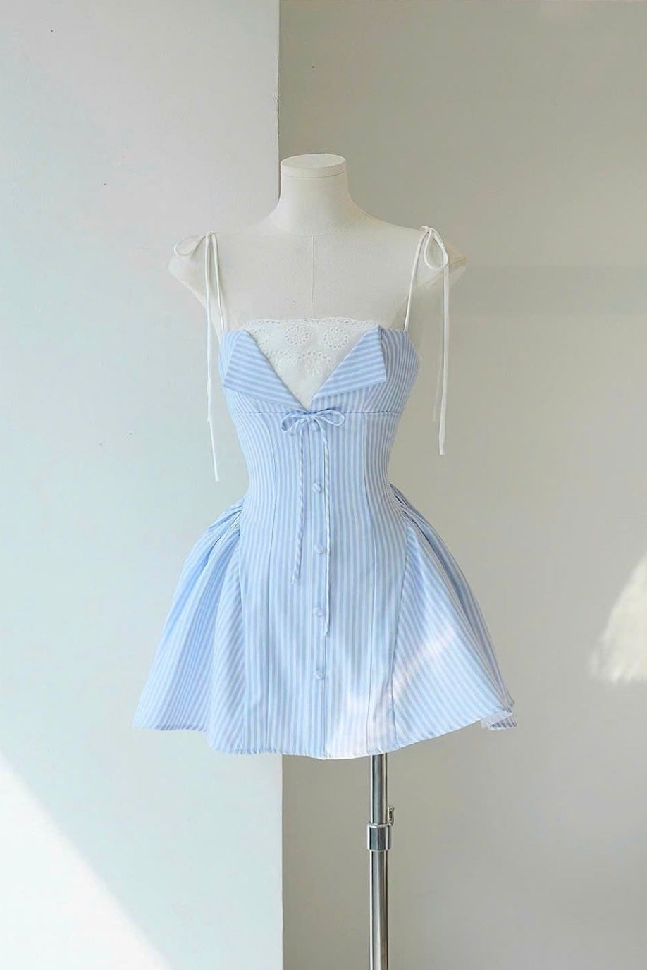 Light blue striped dress on a mannequin against a white wall