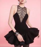 Black dress with intricate detailing on a pink background