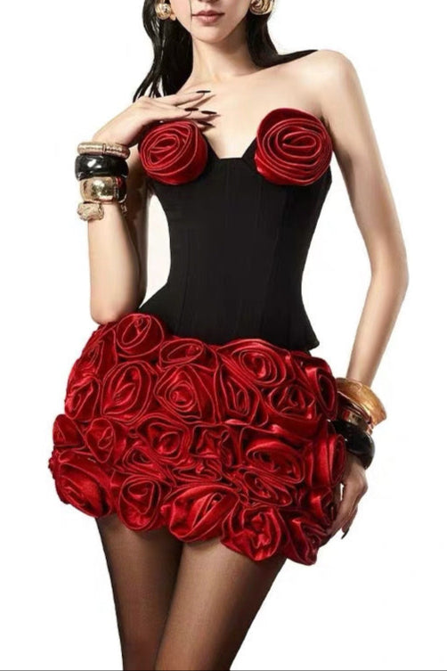 Woman wearing a black and red dress with rose details, brand 'KARMA' visible