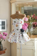 Floral dress on a mannequin in a room with flowers and furniture.