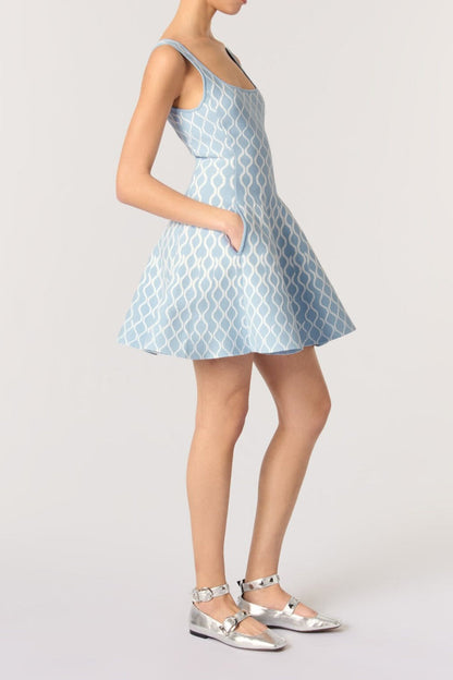 Woman wearing a light blue patterned dress on a white background