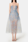 A model wearing a blue beaded lace mini dress with a fitted bodice and flowing skirt, standing against a white background.