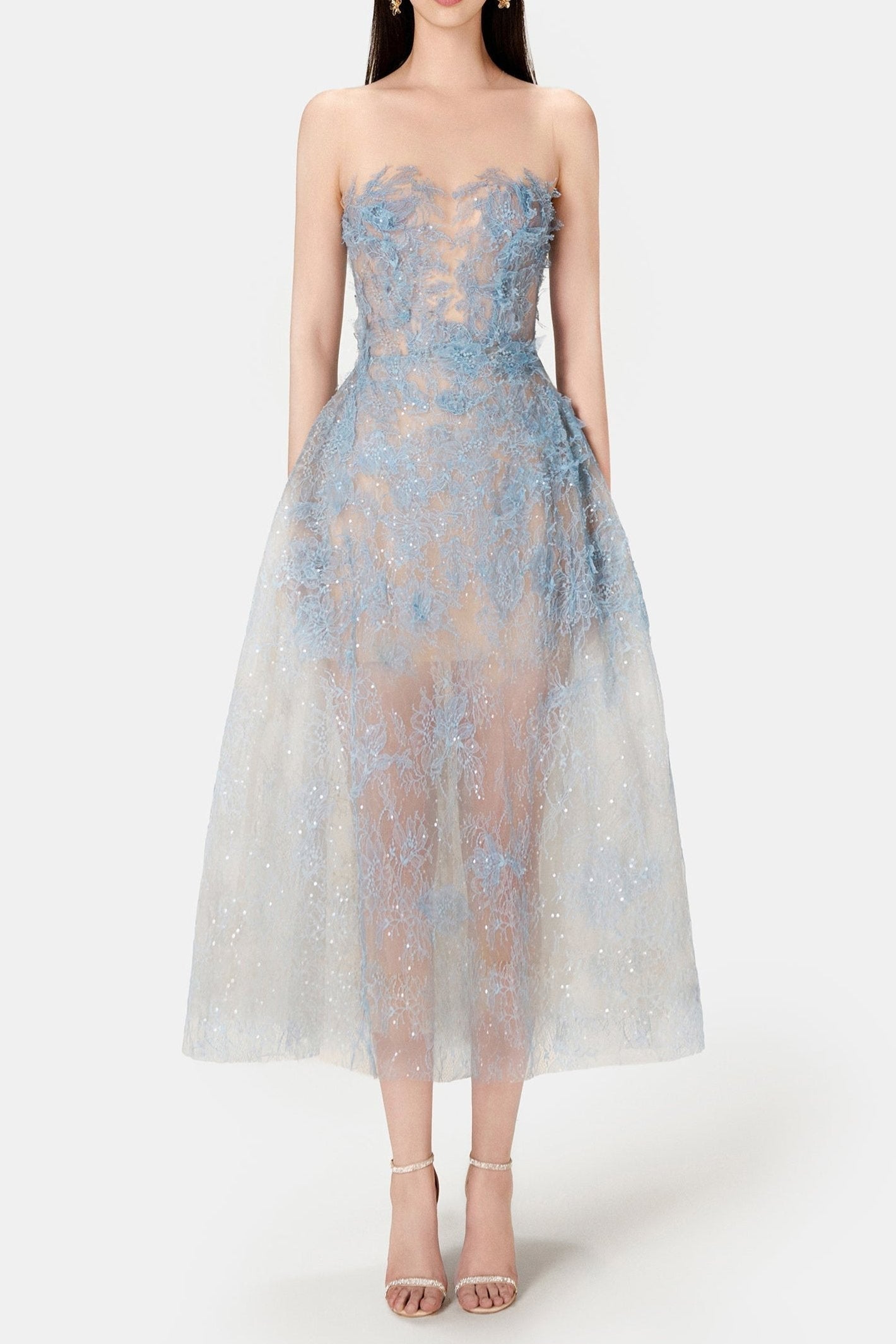 A model wearing a blue beaded lace mini dress with a fitted bodice and flowing skirt, standing against a white background.
