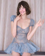 Woman wearing a blue lace dress against a neutral background