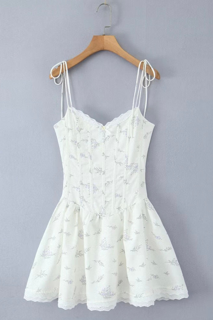 White lace dress on a wooden hanger against a gray background