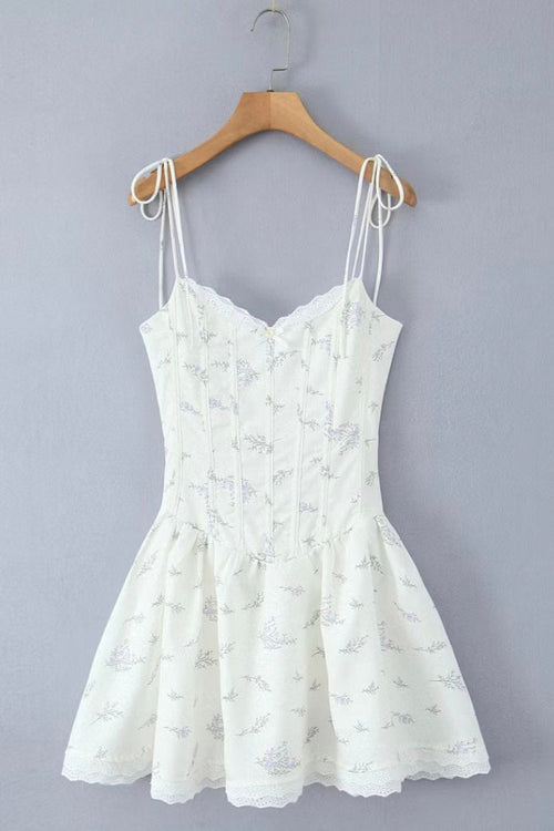 White lace dress on a wooden hanger against a gray background